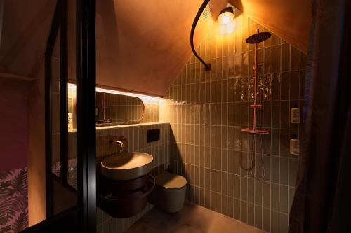 La petite salle de bains est pourvue d'un lavabo et d'une douche. dans l'établissement bosbAAr, à Kluisbergen