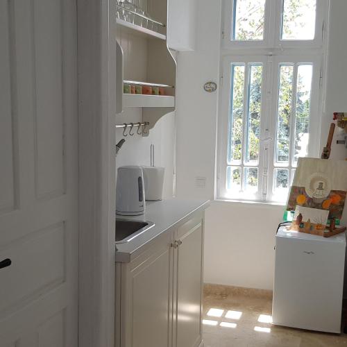 a kitchen with white cabinets and a window at Old Town Apartament in Târgovişte