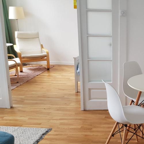 a living room with white chairs and a table at Old Town Apartament in Târgovişte