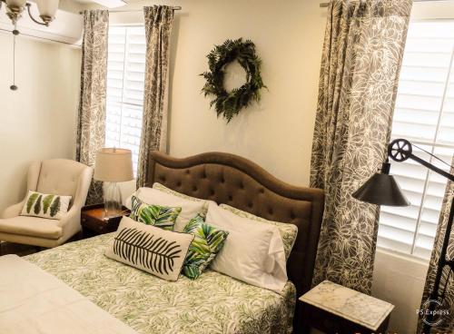 a bedroom with a bed with pillows and a chair at Isla Verde by the Beach in San Juan