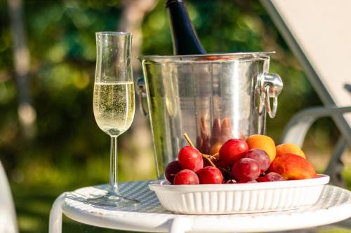 a bowl of fruit and a glass of wine on a table at House Garden Loft in Baricella