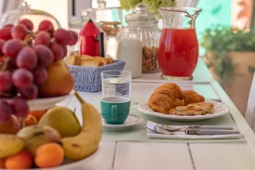 a table topped with plates of fruit and pastries at House Garden Loft in Baricella