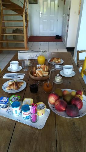 une table en bois avec des assiettes de nourriture dessus dans l'établissement Cador'shouse, à Vaucelles