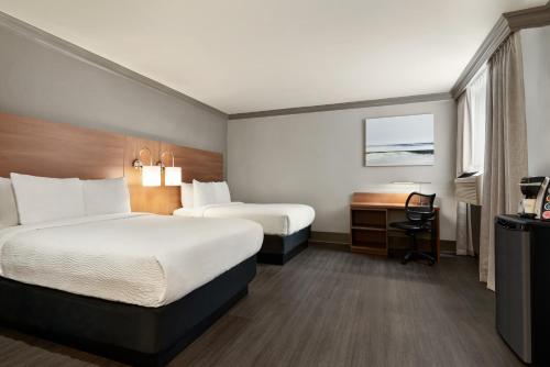 a hotel room with a bed and a desk at Days Inn by Wyndham Vancouver Downtown in Vancouver