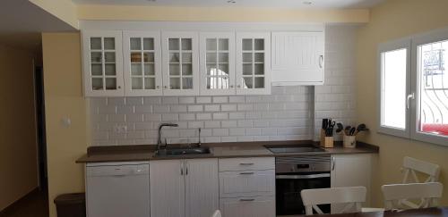 a kitchen with white cabinets and a sink at VALHOME in La Nucía