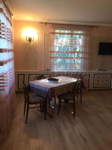 a dining room with a table and chairs and a television at Apple Tree Family Home (ECO) in Dzorakap