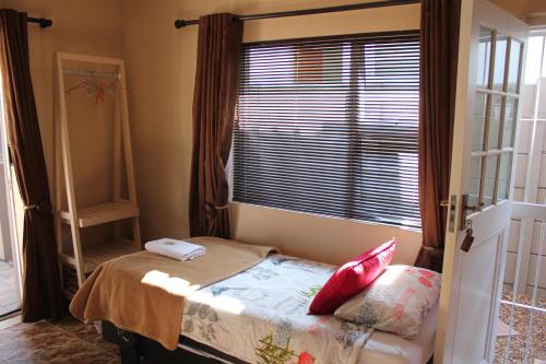 a small bedroom with a bed and a window at 25 on Fitzpatrick in Parow