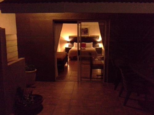 a dark room with a room with a bed and a hallway at 25 on Fitzpatrick in Parow