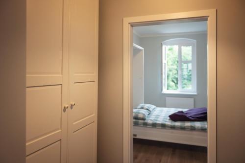 a bedroom with a bed and a mirror and a window at Apartament Terra Pia in Poznań