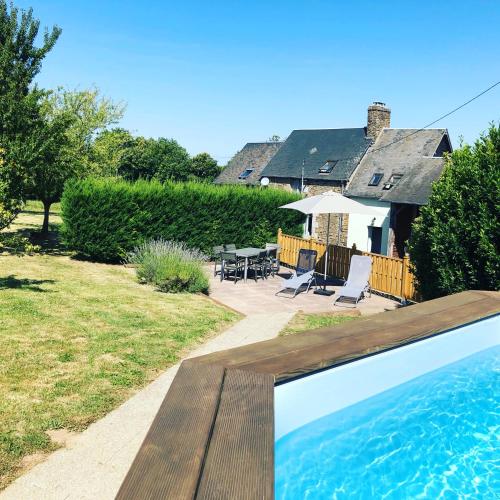 une piscine dans une cour avec une maison dans l'établissement La Besnerais, à Saint-Laurent-de-Terregatte