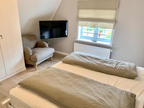 Ein Bett oder Betten in einem Zimmer der Unterkunft Eidumhaus, freistehendes Reetdachhaus mit Garten in Strandnähe