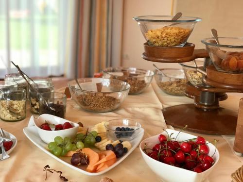 a table topped with bowls of fruit and other foods at Landhotel Moorhof in Franking