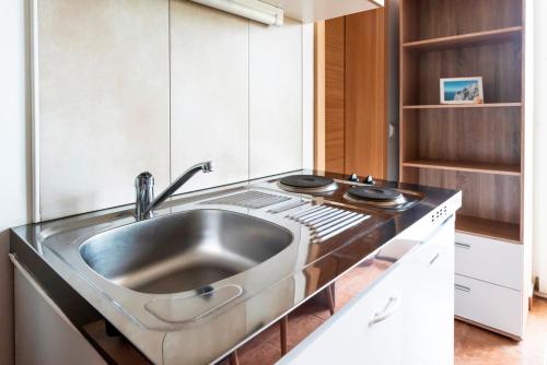 a kitchen with a sink and a stove at Lavanda Apartments&Studios in Pinezici