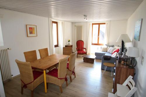 a living room with a wooden table and chairs at Les Narcisses in Blonay