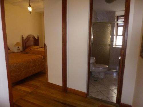 La salle de bains est pourvue de toilettes, d'un lit et d'un miroir. dans l'établissement Hotel Midori, à Cusco