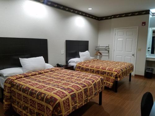 a hotel room with two beds in a room at Scott Inn & Suites - Downtown Houston in Houston