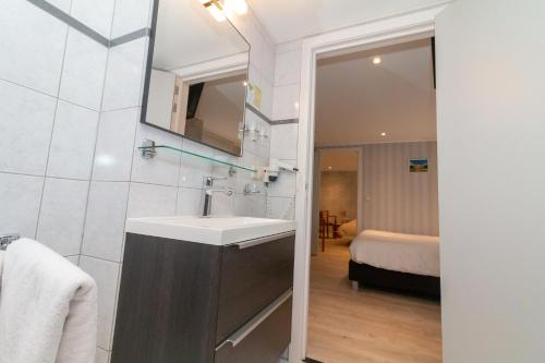 een badkamer met een wastafel, een spiegel en een bed bij Hotel het Anker in Valkenburg