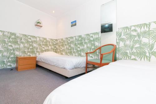 um pequeno quarto com 2 camas e uma cadeira em Hotel het Anker em Valkenburg