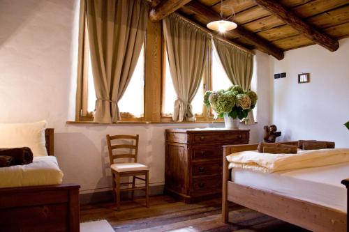 a bedroom with a bed and a dresser and a window at Contrada Beltramelli in Villa di Tirano