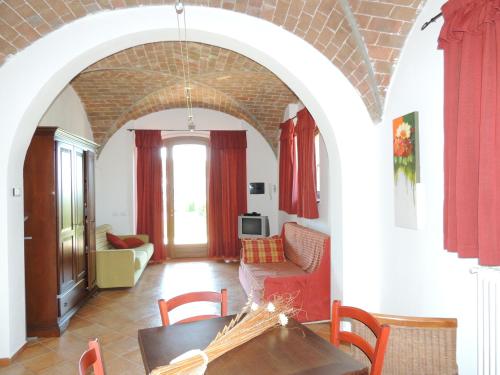 a living room with red curtains and a table at Casa Vacanza Il Malandrone in Vada