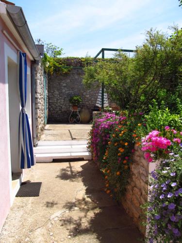 a garden with flowers on the side of a building at Apartments Anita in Veli Lošinj