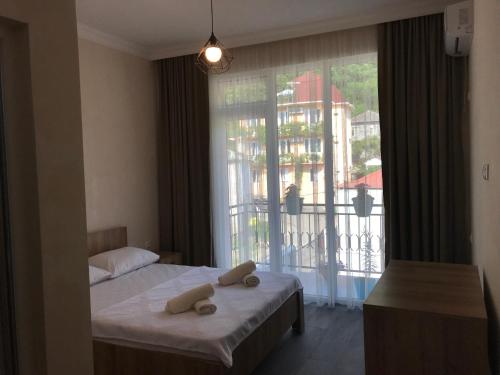 a bedroom with a bed and a large window at Hotel CHARLI in Gonio