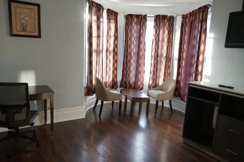 a living room with a table and chairs and a window at The Utah Inn in San Francisco