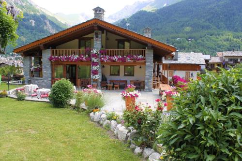 a house with a bunch of flowers in front of it at Hotel Lo Campagnar in Courmayeur