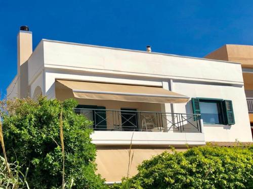 a white house with a balcony at Rio Beach Residence in Patra
