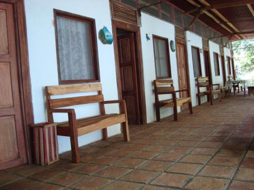 a row of wooden benches sitting on the side of a building at Hotel Ecológico Tierra Blanca in Moyogalpa