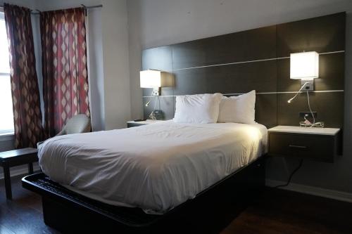 een hotelkamer met een groot bed en twee lampen bij The Utah Inn in San Francisco