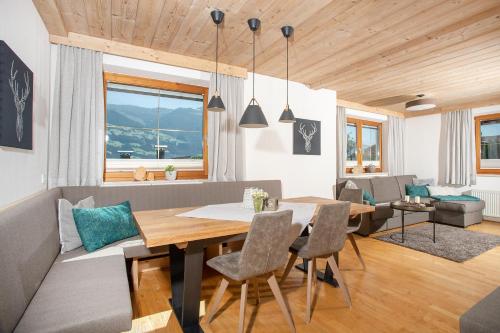 ein Esszimmer und ein Wohnzimmer mit einem Tisch und Stühlen in der Unterkunft "Chalet Bergzeit" Ferienhaus mit Sauna & Wellness in Fügenberg
