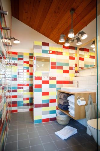 a bathroom with a colorful striped wall at Lenai & Linai Apartments in Lech am Arlberg