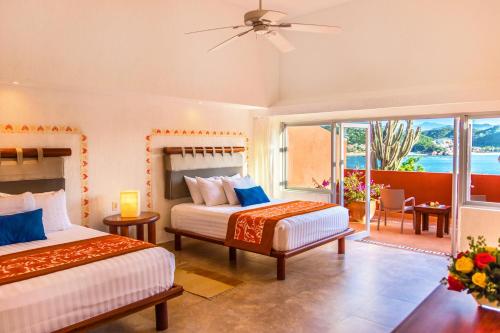 sypialnia z 2 łóżkami i balkonem w obiekcie Las Brisas Huatulco w mieście Santa Cruz Huatulco