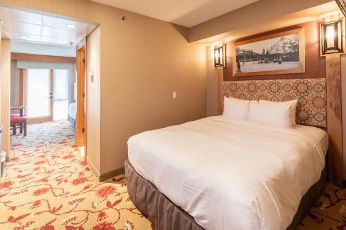 a bedroom with a large white bed in a room at Banff Ptarmigan Inn in Banff