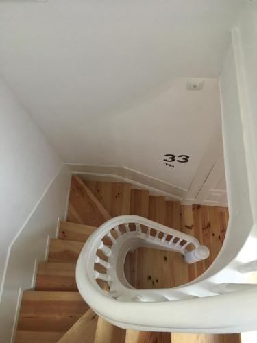 uma escada em espiral numa casa com pisos em madeira em Pimms Home Ribeira em Porto