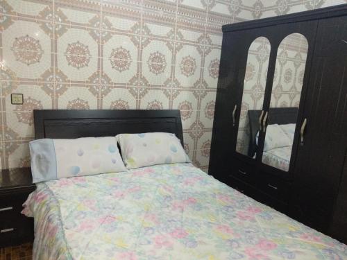 1 dormitorio con 1 cama con tocador y espejo en Appartement belle vue, en M'diq