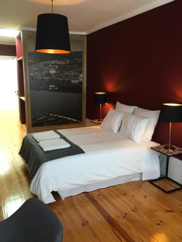 a bedroom with a large white bed and two lamps at Pimms Home Ribeira in Porto