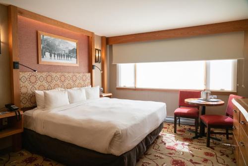 a hotel room with a large bed and a window at Banff Ptarmigan Inn in Banff