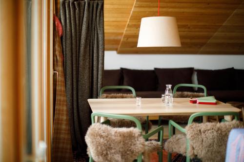 stół z zielonymi krzesłami i lampką nad nim w obiekcie Lenai & Linai Apartments w Lech am Arlberg