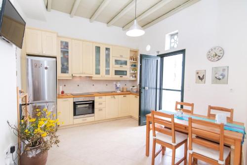 a kitchen with a table and a refrigerator at ''Cactus'' Traditional house in Vólax