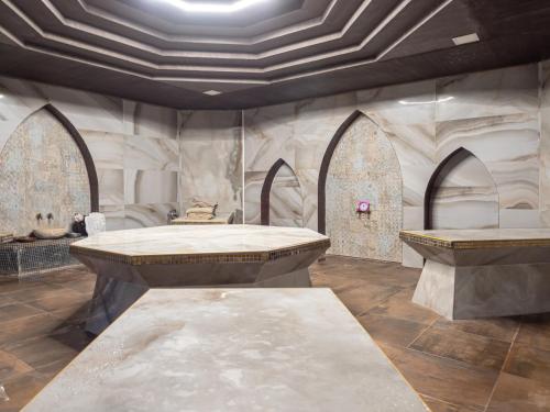 een kamer met 2 tafels en een stenen muur bij Aqua Paradise Resort & Aqua Park in Nesebar