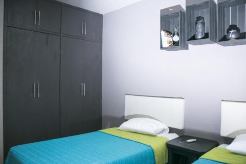 ein Schlafzimmer mit zwei Betten und schwarzen Schränken in der Unterkunft COLONIAL SUITES # DOS in Ciudad Valles