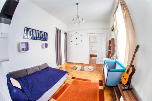 een woonkamer met een bank en een gitaar bij Inner City Apartment in Debrecen