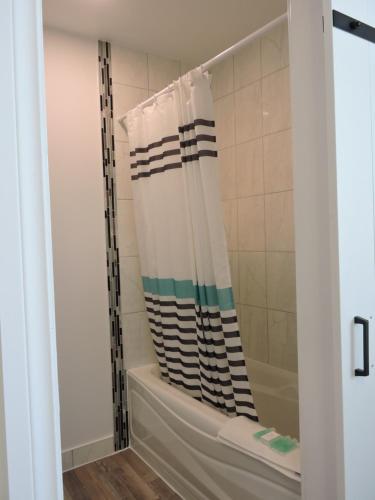 a shower with a striped shower curtain in a bathroom at Almo Court Motel in Cranbrook