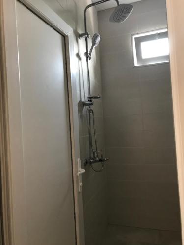 a shower with a glass door in a bathroom at Hotel CHARLI in Gonio