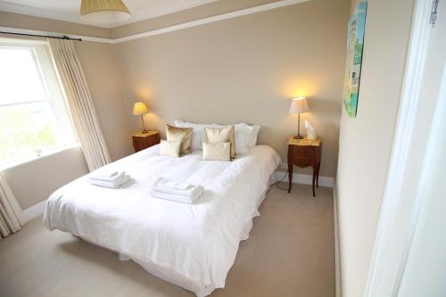 - une chambre avec un grand lit blanc et deux lampes dans l'établissement Victorian Annexe - Bath, à Bath