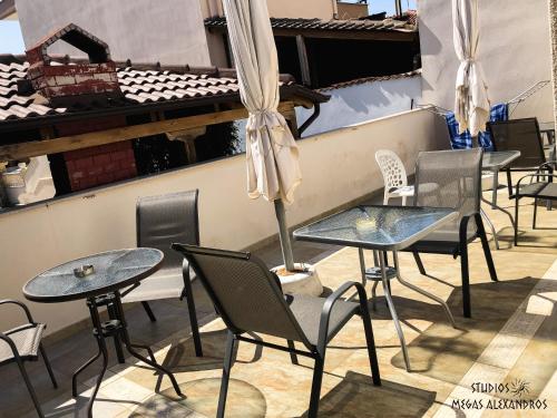 a row of tables and chairs in a restaurant at Studios Megas Alexandros in Nea Vrasna