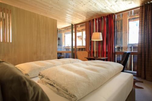 sypialnia z 2 łóżkami i stołem z lampką w obiekcie Lenai & Linai Apartments w Lech am Arlberg