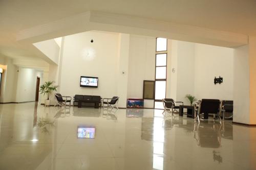 a large room with chairs and a tv on the wall at Hotel Rustavi in Rustavi